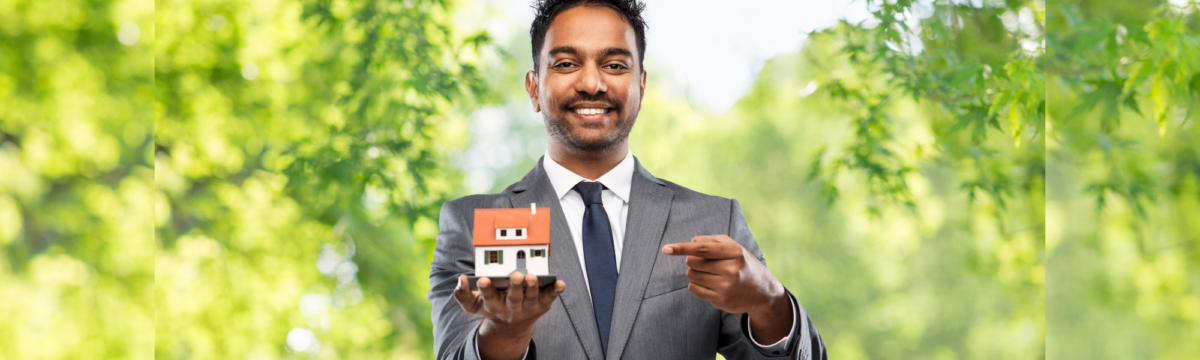 a realtor holding a toy house